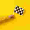 A hand holding a chequered flag
